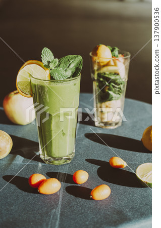 A healthy green smoothie made with fresh spinach, standing on a table with a turquoise tablecloth A healthy green smoothie made with fresh spinach, standing on a table with a turquoise tablecloth 137900536
