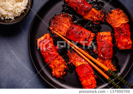 Bacon roll with enoki mushroom grilled with sauce. 137900709