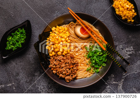 A bowl of ramen with noodles, meat and green onions. 137900726