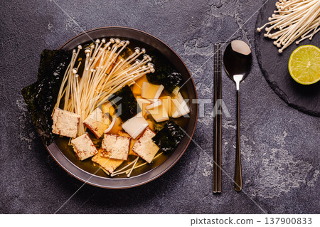Asian-style soup with squid, tofu and enoki mushrooms. Asian-style soup with squid, tofu and enoki mushrooms. 137900833