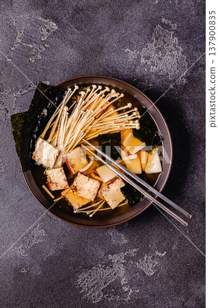 Asian-style soup with squid, tofu and enoki mushrooms. Asian-style soup with squid, tofu and enoki mushrooms. 137900835
