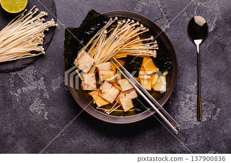 Asian-style soup with squid, tofu and enoki mushrooms. Asian-style soup with squid, tofu and enoki mushrooms. 137900836