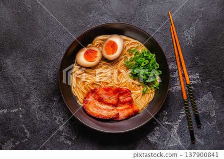A bowl of ramen with noodles, meat and green onions. 137900841