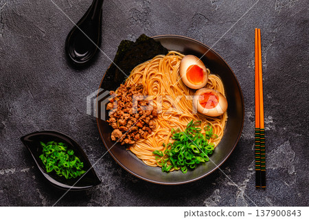A bowl of ramen with noodles, meat and green onions. 137900843