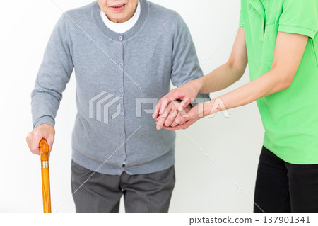 Care workers assisting elderly people with mobility issues. Care workers assisting elderly people with mobility issues. 137901341