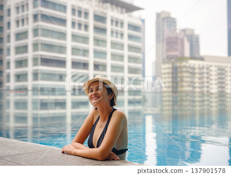 Young woman relaxing by the pool at a Kuala Lumpur hotel 137901578