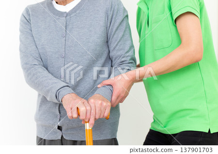 Care workers assisting elderly people with mobility issues. Care workers assisting elderly people with mobility issues. 137901703