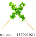 Fresh green bell pepper slices on wooden skewers arranged in an X shape isolated. Healthy vegetable kebab concept, vegan appetizer ingredients for grill or barbecue cooking. 137901921