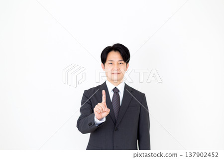 Middle-aged male businessman in a suit pointing his index finger 137902452