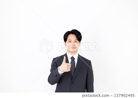 Middle-aged male businessman in a suit showing thumbs up 137902495