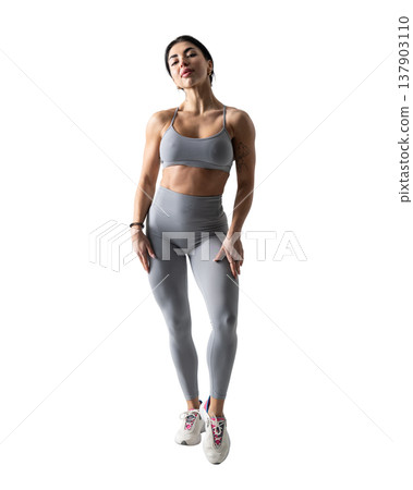 Athletic woman with a strong body wearing an activewear set on a white background 137903110