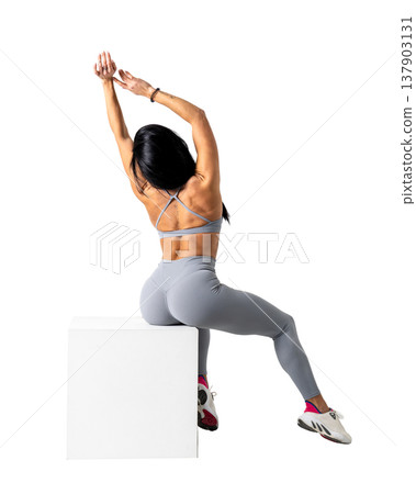 Athletic woman with a strong body wearing an activewear set on a white background 137903131