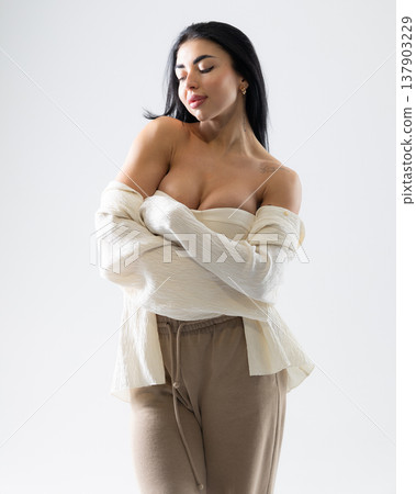 Woman posing with white shirt and brown pants on a white background Woman posing with white shirt and brown pants on a white background 137903229