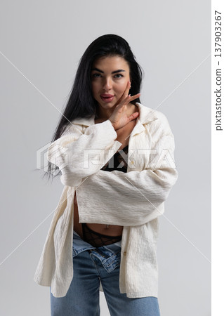Attractive woman undressing, wearing lingerie and jeans, white studio background Attractive woman undressing, wearing lingerie and jeans, white studio background 137903267