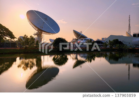 Large satellite dish antenna station by pond at dawn, Bangkok Large satellite dish antenna station by pond at dawn, Bangkok 137903859