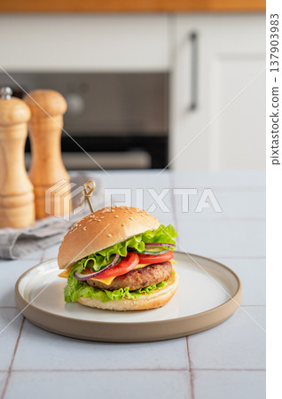 Meat burger with tomato, cheese, and lettuce on a plate on a table with spice Meat burger with tomato, cheese, and lettuce on a plate on a table with spice 137903983