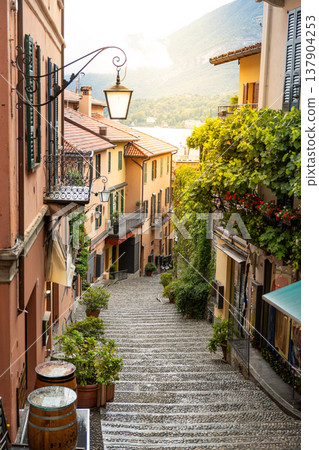 Charming Empty European Old Town Alley with Stone Steps and Mountain Lake View 137904253