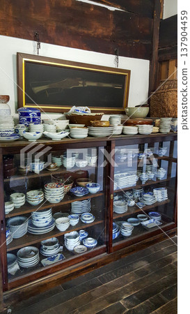 A photo of an old cabinet filled with blue-and-white Japanese porcelain in a traditional house A photo of an old cabinet filled with blue-and-white Japanese porcelain in a traditional house 137904459