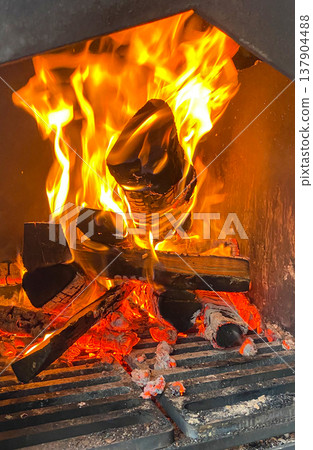 A vibrant image of burning firewood in a smoker creates a warm and inviting atmosphere. 137904488