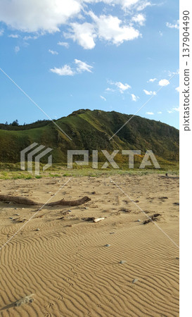 A picturesque scene depicting green hills along the Kuril Islands' coastline on a bright summer day. A picturesque scene depicting green hills along the Kuril Islands' coastline on a bright summer day. 137904490