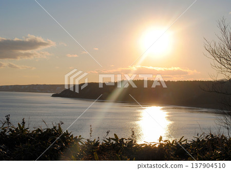 The photograph captures a breathtaking view of a sea bay and autumn forest on the Kuril Islands during sunset on a sunny day. The photograph captures a breathtaking view of a sea bay and autumn forest on the Kuril Islands during sunset on a sunny day. 137904510