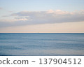The photograph showcases a stunning view of a sea bay on the Kuril Islands at sunset, with vessels gently resting on the water. 137904512