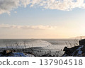 The breathtaking coastline of a Kuril Islands bay glistens at sunset on a sunny winter day. 137904518