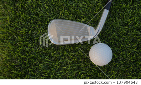 Golf grove and golf balls on a green lawn in a beautiful golf course with morning sunshine. 137904648