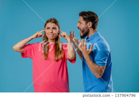 Angry man yelling at tired woman, she sighs and rolls eyes in frustration.Couple Angry man yelling at tired woman, she sighs and rolls eyes in frustration.Couple 137904796