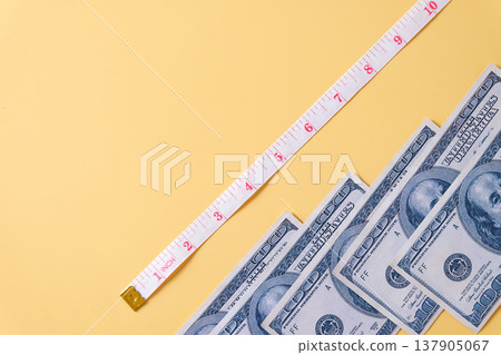 US dollars money bills and measuring tape on color background. 137905067