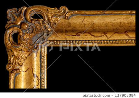 Detailed View of a Golden Ornate Picture Frame Showcasing Intricate Designs and Textures in Dim Lighting 137905094