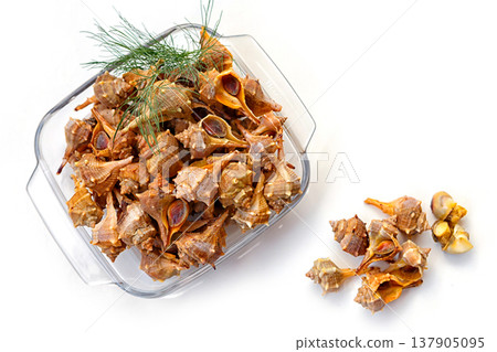 Seafood Dish Made With Dried Shellfish Placed in a Glass Container on a White Surface With Green Herbs Nearby Seafood Dish Made With Dried Shellfish Placed in a Glass Container on a White Surface With Green Herbs Nearby 137905095