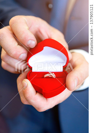 wedding rings in hand. wedding rings in the hands of the groom. wedding rings in hand. wedding rings in the hands of the groom. 137905121