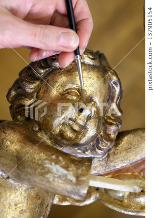 Artisan Restores Old Statue of Cherub in Workshop to Preserve Cultural Heritage and Craftsmanship 137905154