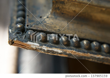 Close View of an Old Wooden Frame With Metal Detailing Showing Wear and Age From Years of Use in a Historical Setting Close View of an Old Wooden Frame With Metal Detailing Showing Wear and Age From Years of Use in a Historical Setting 137905159