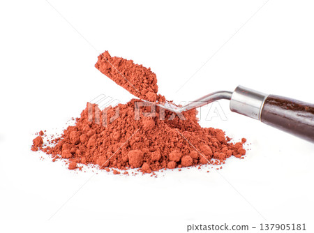 Bright Orange pigment Spice Spilling From Container With Scoop on White Background Bright Orange pigment Spice Spilling From Container With Scoop on White Background 137905181