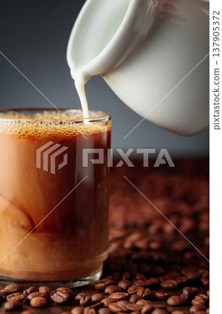 Cream is added to the coffee. Cream is added to the coffee. 137905372