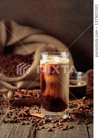 Iced coffee with cream on an old wooden table. Iced coffee with cream on an old wooden table. 137905383