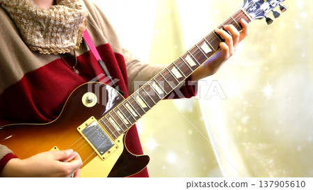 Close-up of a person playing an electric guitar: wearing a red suit. Close-up of a person playing an electric guitar: wearing a red suit. 137905610