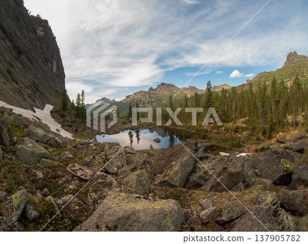 Mountain lake mirrors sky and peaks Mountain lake mirrors sky and peaks 137905782