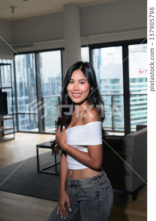 Young Asian woman standing in a modern high-rise apartment with city view in Kuala Lumpur, Malaysia Young Asian woman standing in a modern high-rise apartment with city view in Kuala Lumpur, Malaysia 137905798