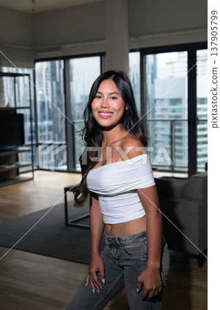 Young Asian woman standing in a modern high-rise apartment with city view in Kuala Lumpur, Malaysia Young Asian woman standing in a modern high-rise apartment with city view in Kuala Lumpur, Malaysia 137905799