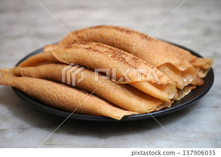 Side View of Traditional Bengali Sweet Patisapta Pitha Served on a Black Plate Side View of Traditional Bengali Sweet Patisapta Pitha Served on a Black Plate 137906035