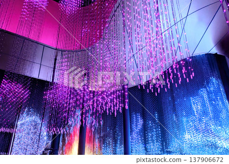 A fantastical illumination of pink and blue specks of light raining down from the ceiling. 137906672