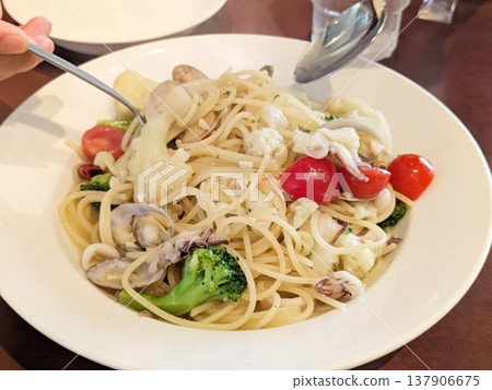 Authentic peperoncino with clams and squid, served with a colorful array of steamed vegetables. Authentic peperoncino with clams and squid, served with a colorful array of steamed vegetables. 137906675