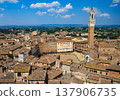 A panoramic view over Piazza del Campo, the heart of Siena, surrounded by medieval buildings and dominated by the Torre del Mangia. 137906735
