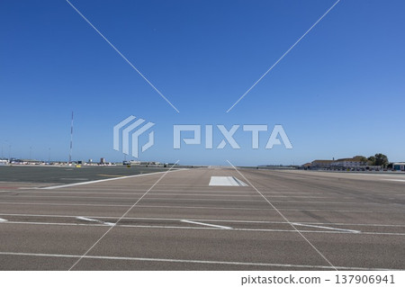 Gibraltar airport runway with clear blue sky and no visible aircraft or activity during the day 137906941
