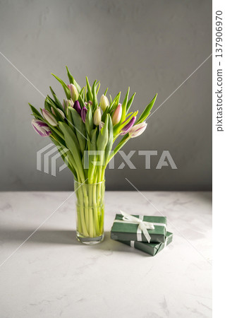 Spring floral background. Fresh purple and pink tulips flowers bouquet in glass vase and gift boxes. Mother's day. Spring floral background. Fresh purple and pink tulips flowers bouquet in glass vase and gift boxes. Mother's day. 137906970