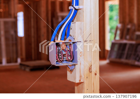 Wiring box on wooden post in construction site at electrical setup ongoing work 137907196