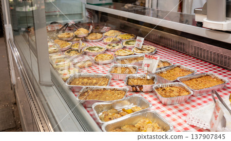 Genoa, liguria, italy. May 18, 2024. Displaying traditional italian deli food including savory pies, meatloaf, and side dishes on a red gingham tablecloth Genoa, liguria, italy. May 18, 2024. Displaying traditional italian deli food including savory pies, meatloaf, and side dishes on a red gingham tablecloth 137907845